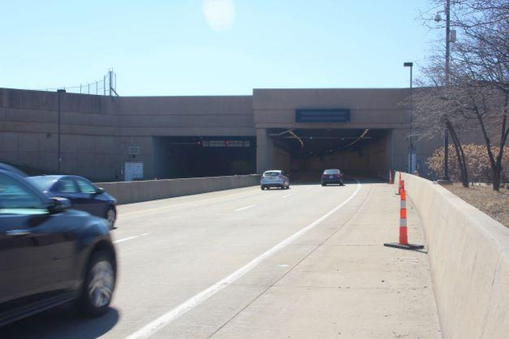 Photo of multiple cars entering a tunnel on a road