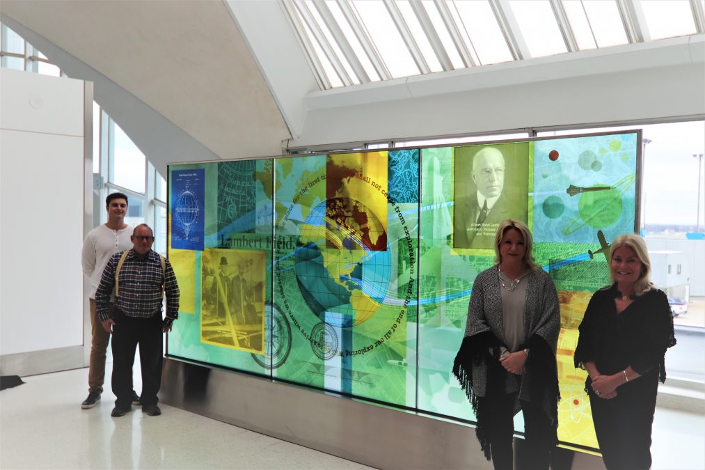 Photo of a family of four people standing in front of an art exhibit