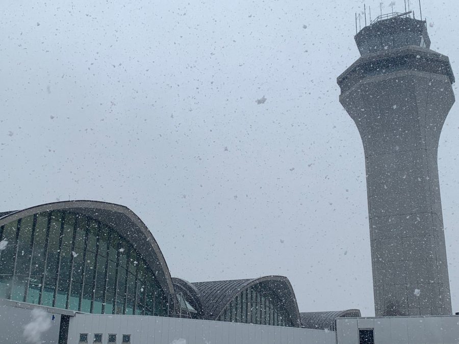 Photo of the exterior of an airport with snow falling
