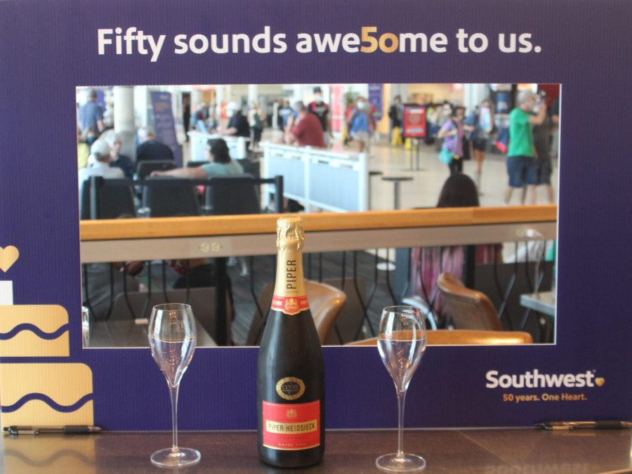 A photo of a celebration frame that says "Fifty sounds awesome to us." with drinks in front of it