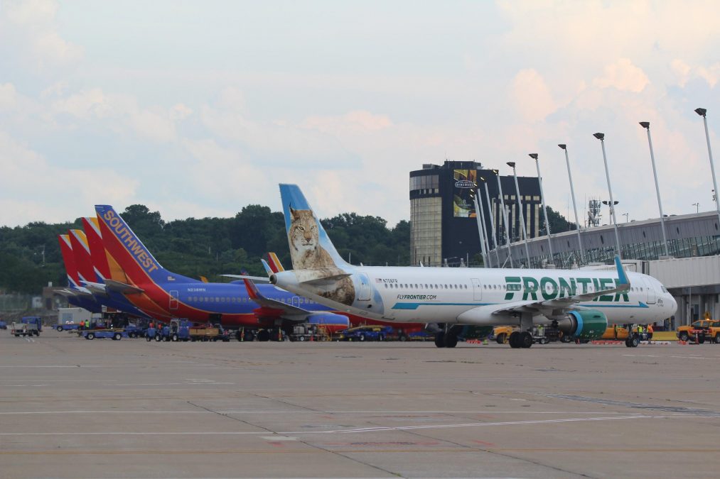 A photo of multiple planes lined up at airport terminals
