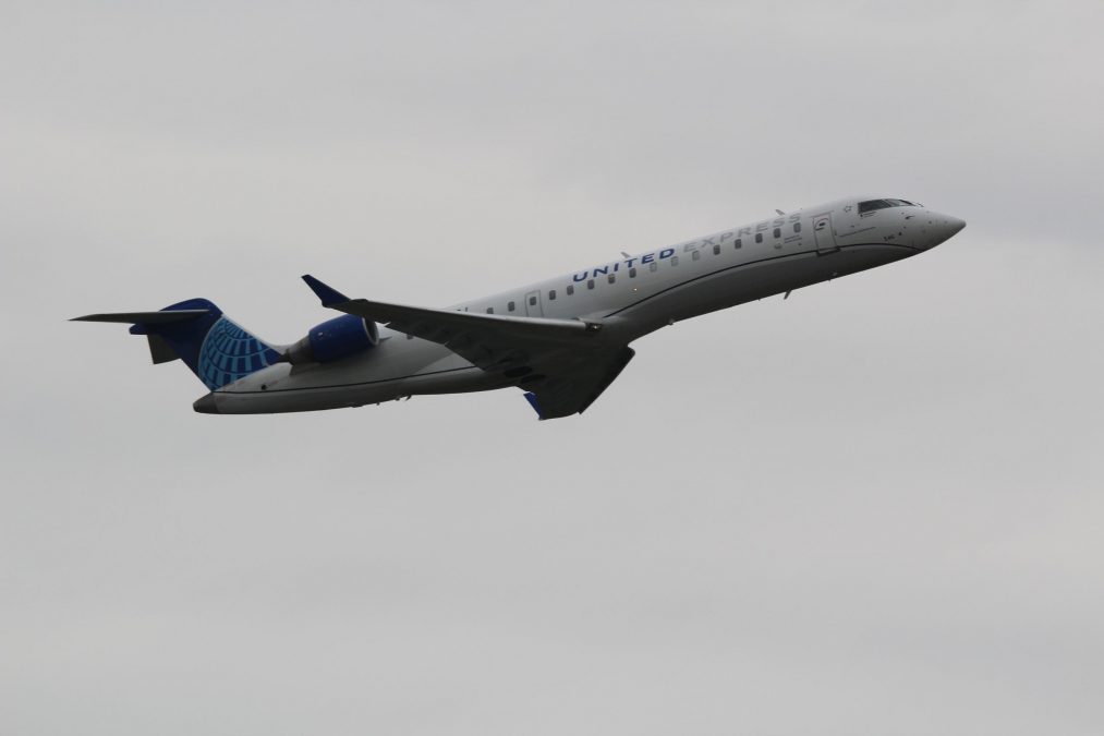 Photo of a United Airlines plane taking off against a gray sky