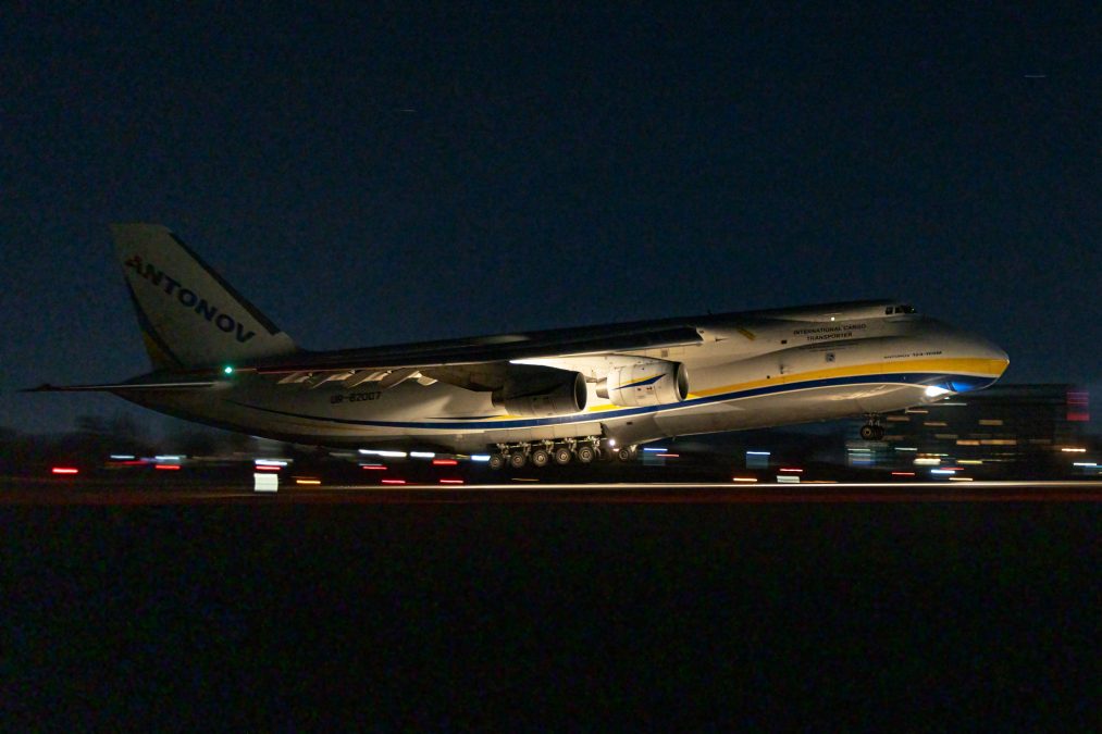 Photo of an Antonov Airlines plane speeding down a runway at nighttime