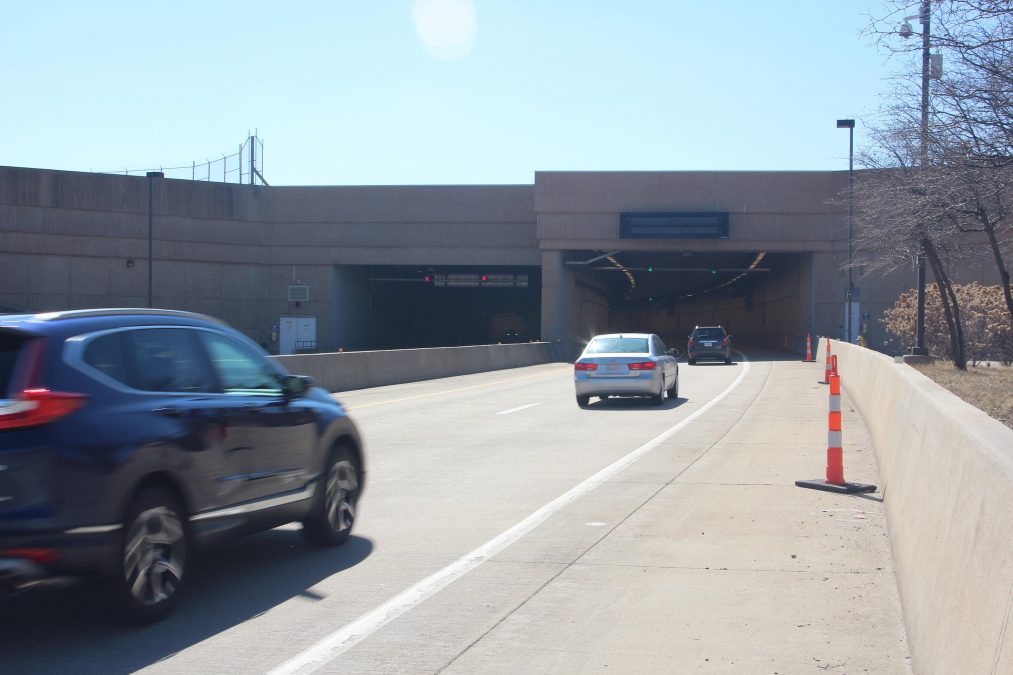 Photo of multiple cars entering a road tunnel during the day