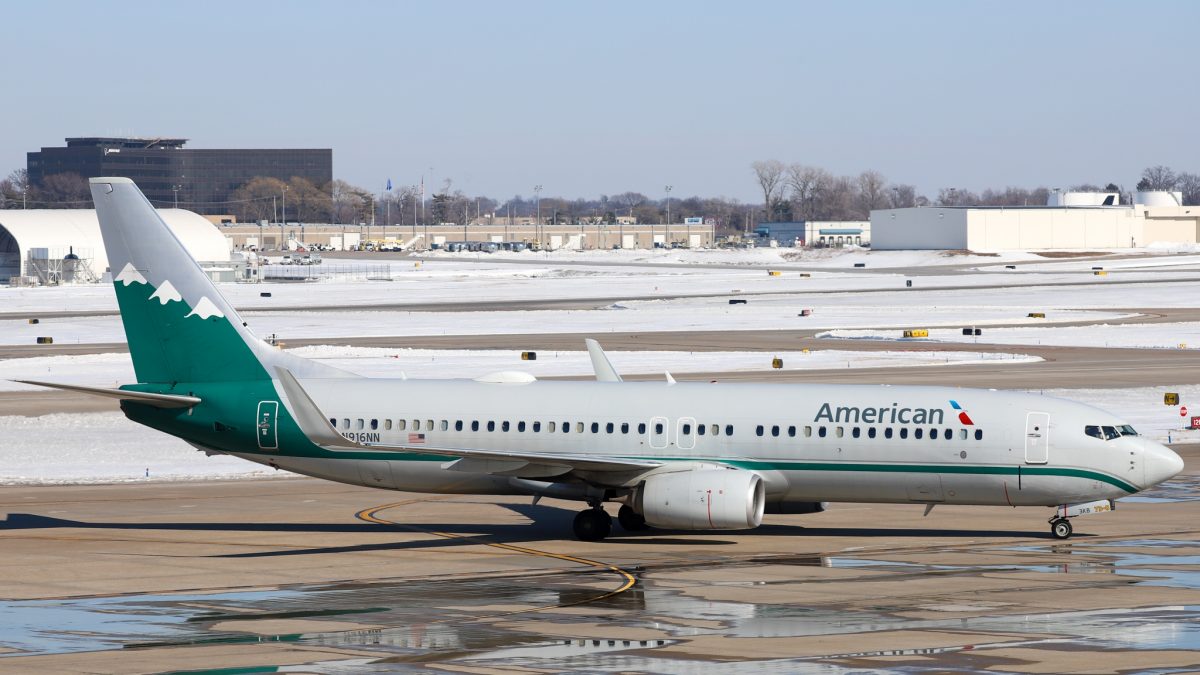 Photo of an American Airlines plane on a runway with a snowy background