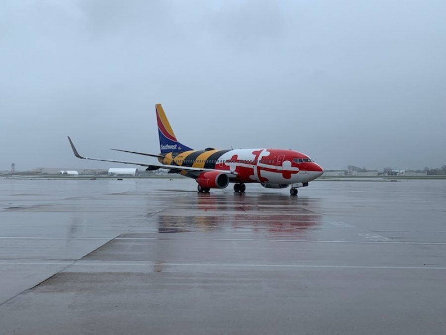 Photo of a Southwest Maryland One plane on a rainy runway with a gray sky in the background. The plane is decorated with the Maryland flag painted on it.