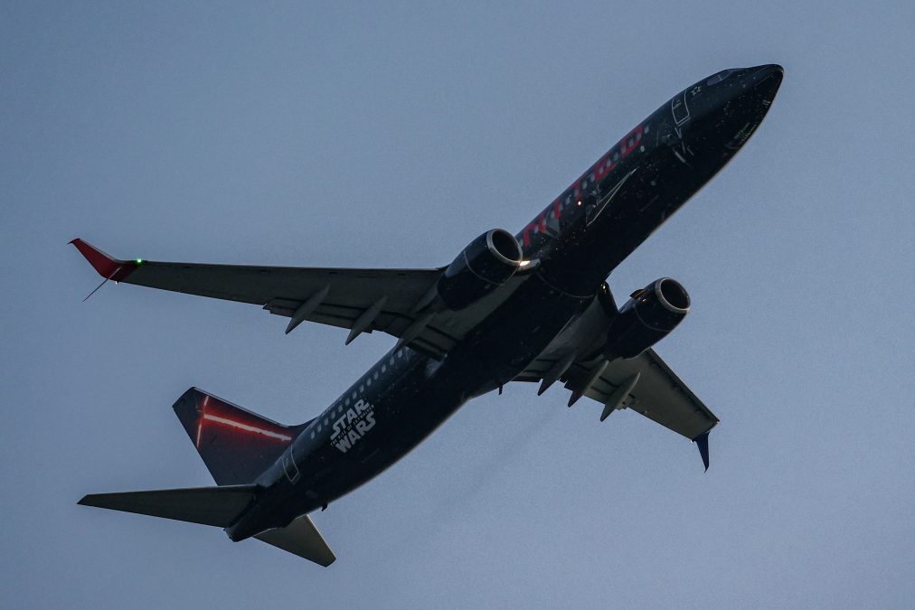 Photo of a black United plane with Star Wars branding on the side flying through the air