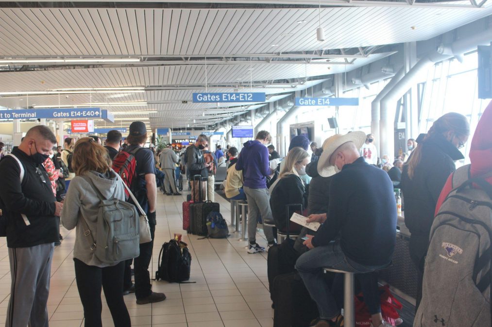 Photo of dozens of people waiting at an airport gate