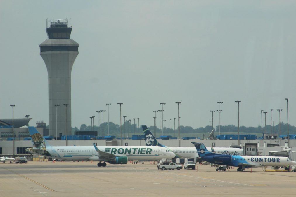 Photo of a Frontier plane at an airport with several other smaller planes around it
