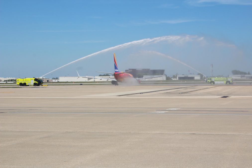 Photo of multiple fire trucks on opposite sides of a Southwest Airlines plane on a runway