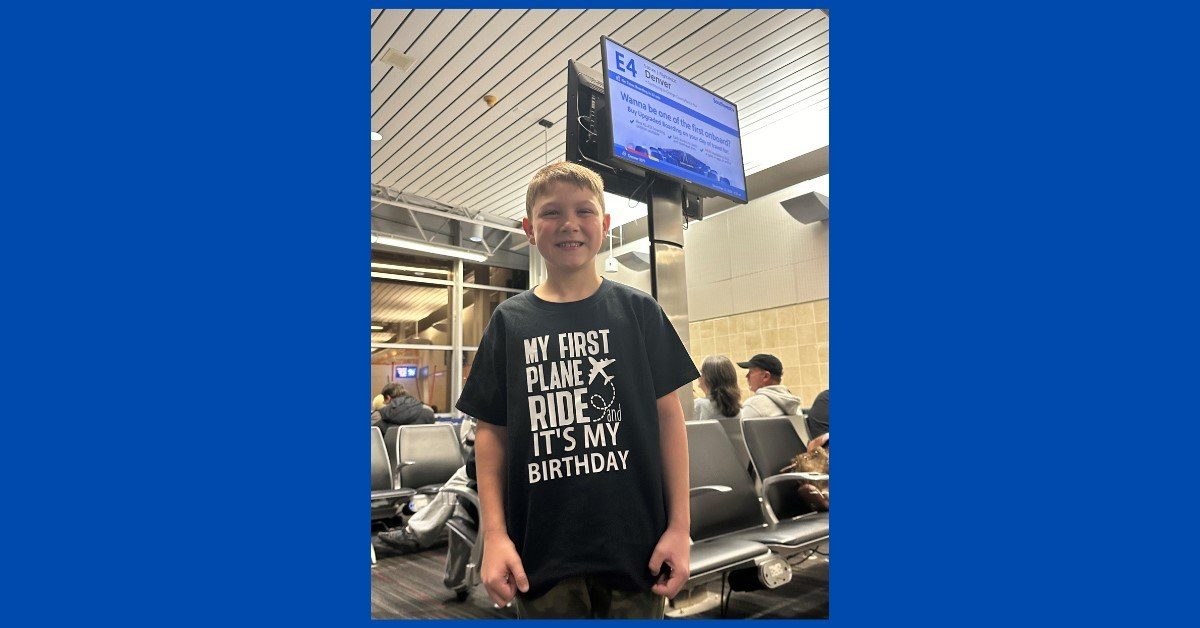 A photo of a boy in the airport with a shirt that reads "My first plane ride! It's my birthday!"
