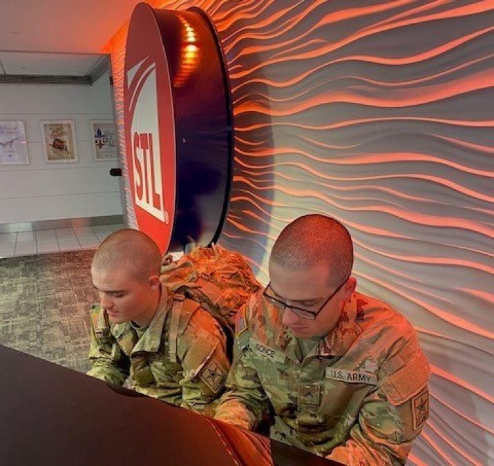A couple of servicemen traveling through STL stop to play us a melody on the piano that sits on the stage in the baggage claim area of T1.