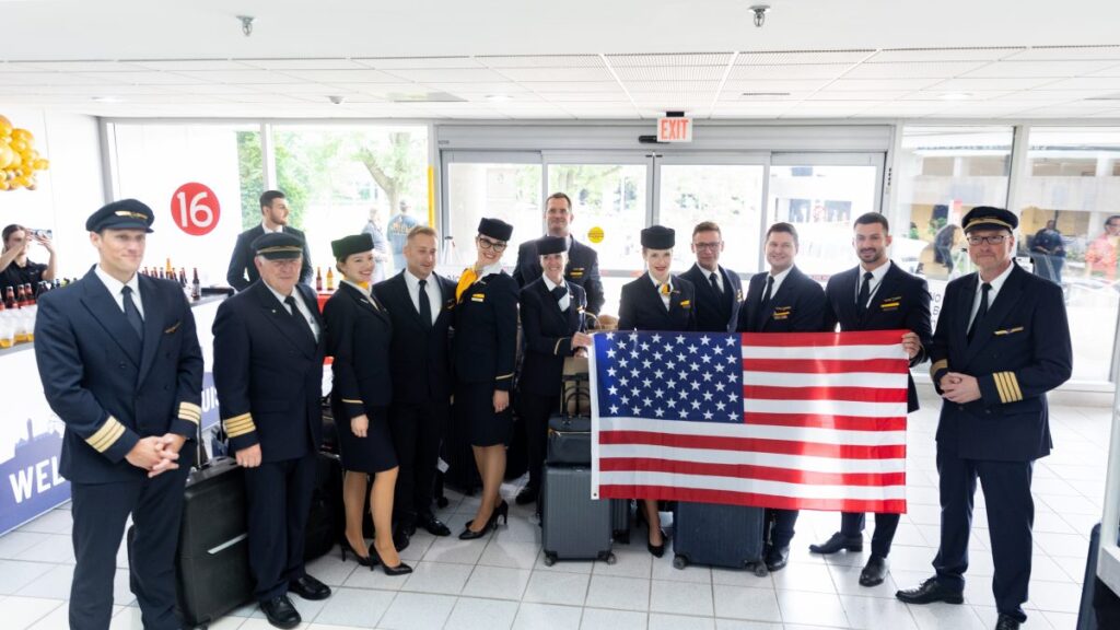 Photo of airline crew holding the American flag.