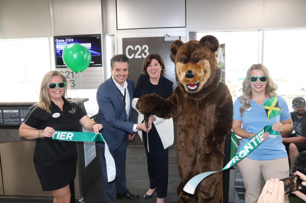 Team members cut the Frontier ribbon for the inaugural flight from STL to Montego Bay.