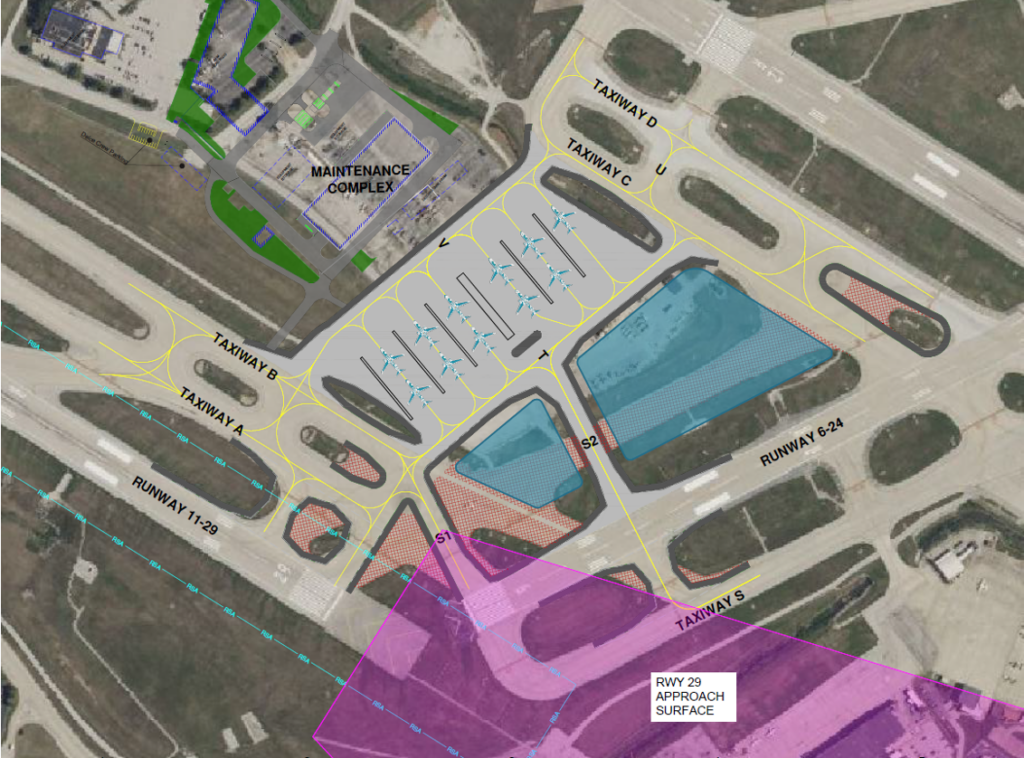 An annotated aerial map of an airport's west airfield program, showing taxiways, runways, aircraft parking areas, and a maintenance complex. The map includes labeled taxiways (A, B, C, D, S, U, T, V, S1, S2) and runways (6-24 and 11-29). The maintenance complex is outlined in blue near the top of the image. Various shaded areas indicate infrastructure modifications, with a purple section labeled 'RWY 29 Approach Surface' highlighting an approach path. Yellow lines depict taxiway pathways, and red-hatched areas represent restricted or construction zones.