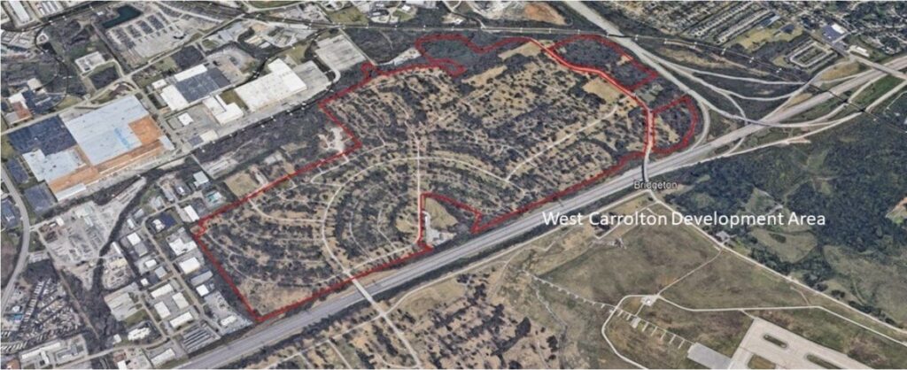 An aerial view of the West Carrolton Development Area, outlined in red, showing a mix of wooded land, open spaces, and remnants of a former residential neighborhood. The area is bordered by a highway at the bottom and industrial buildings at the top left. Roads and infrastructure from the previous development are still visible, with curved streets and driveways remaining. The surrounding region includes commercial, industrial, and undeveloped land, with the label 'Bridgeton' appearing near the highway.