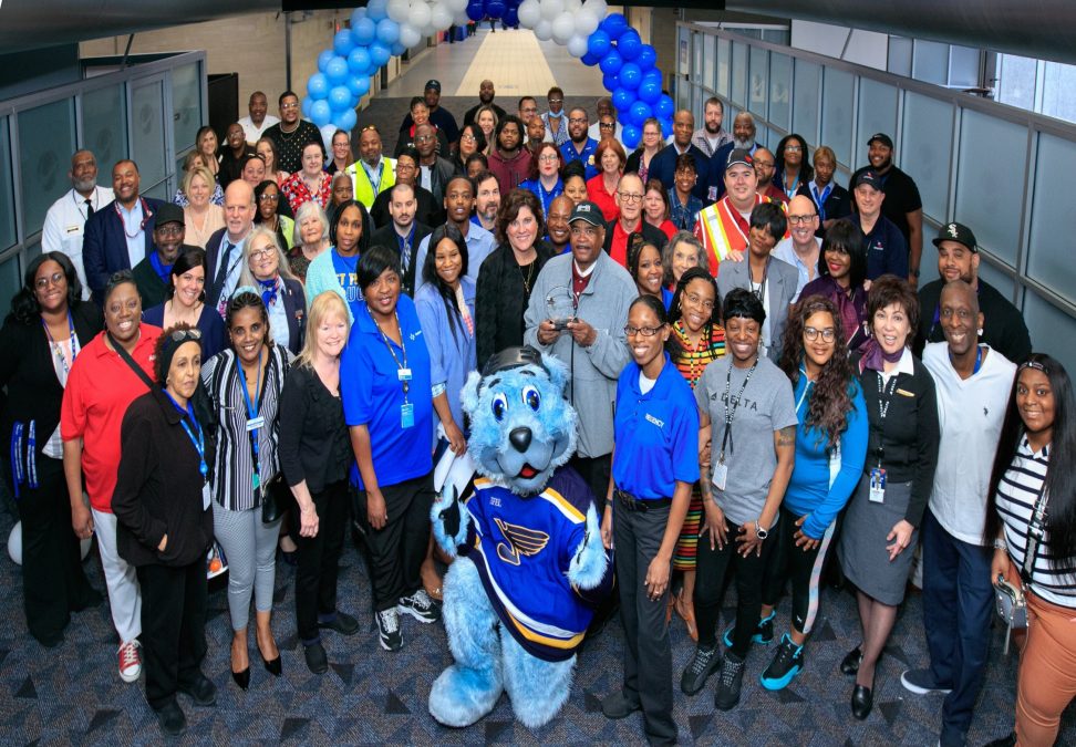 A group photo of the catch us giving nominees at the airport with St. Louis Blues' mascot Bluey.