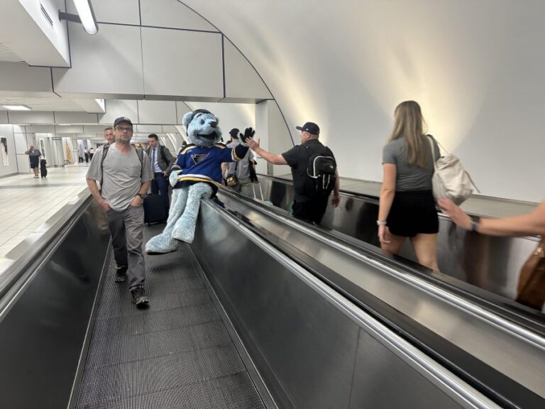 Riding the Rails: Louie the Bear, mascot of the St. Louis Blues, greets travelers along the moving walkway at STL’s Terminal 2.