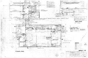 Detailed architectural blueprint showing the floor plan, plot plan, and various measurements for a residential building project, with room labels, symbols, construction notes, and a title block in the upper right corner.