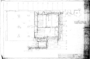Architectural floor plan drawing showing walls, rooms, and measurements for a building addition, including labeled sections, doorways, and exterior features. The right side has a legend and scale; edges are faded.