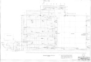 Black and white architectural floor plan drawing of a commercial or industrial building showing rooms, grid lines, doors, walls, detailed labels, dimensions, and notes, with a title block in the lower right corner.