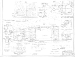 Architectural blueprint with detailed technical drawings, measurements, and annotations for site grading, drainage, sidewalk layout, curb ramps, and existing utility locations at a street intersection.