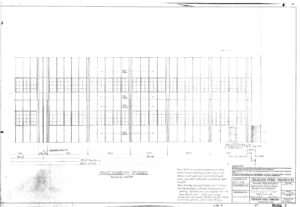 Architectural blueprint showing the front elevation of an industrial building, labeled with measurements, window and door placements, structural gridlines, and a title block in the lower right corner.
