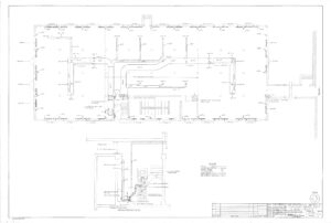 Architectural floor plan drawing showing a large rectangular building with labeled rooms, doors, walls, and internal pathways. Includes detailed lines, measurements, and a smaller inset plan at the bottom left.