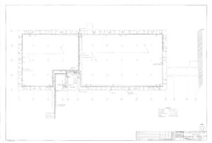 Architectural floor plan of a large rectangular building with labeled rooms, walls, doors, and entrances. The drawing includes technical details, measurements, and a title block in the lower right corner.