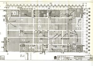 Black and white factory floor plan labeled McDonnell, with numbered sections, arrows, grid overlays, handwritten numbers, and notes. Includes a scale, north arrow, and labeled rooms and aisles throughout the layout.