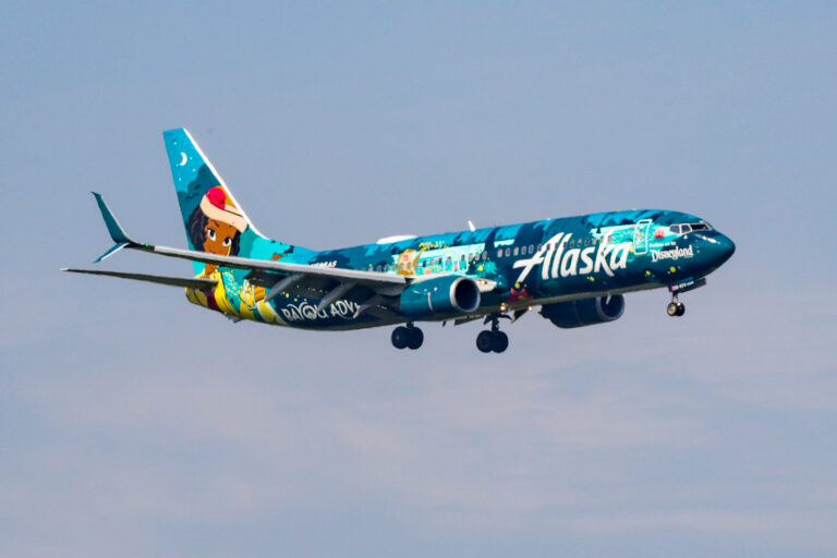 Photo showing Alaska Airlines' newest livery, Tiana’s Bayou Adventure Flyer in the sky. The plane features a hand-painted mural of Disney's Princess Tiana.