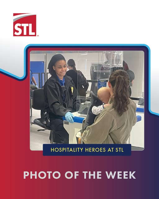 A TSA oficer greets a passenger and checks her ID before clearing her to go through the checkpoint.
